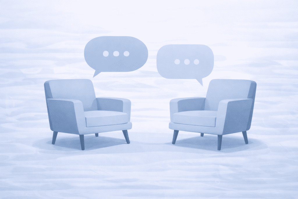 Two armchairs facing each other with speech bubbles above them, each containing three dots, suggesting a conversation or dialogue.
